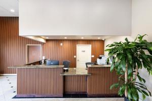Un vestíbulo de oficina con un mostrador de recepción y una planta. en The Prime Suites, Vallejo - Napa Valley and Six Flags Discovery Kingdom, en Vallejo