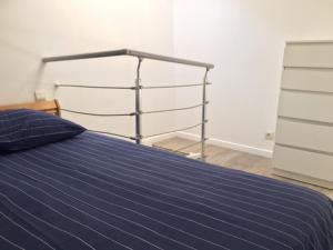 un letto con un piumone blu in una camera da letto di Studio a Eysines