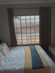 een slaapkamer met een bed met een groot raam bij Nested at L&MX in Centurion