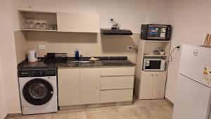 a kitchen with a washing machine and a washer at Dpto Amoblado in Villa María +2 photos