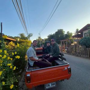 drei Männer sitzen auf der Ladefläche eines Pick-ups in der Unterkunft Yorsong Hostel Pai in Kampong Huaibū