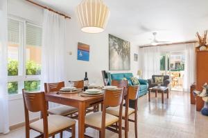 a dining room and living room with a table and chairs at Villa El Olivo in Pollença
