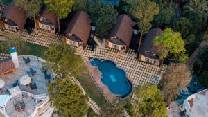 eine Draufsicht auf ein Haus mit Swimmingpool in der Unterkunft Golf Valley Luxury Resort Wayanad in Vythiri