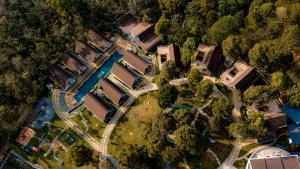 einen Blick über einen Hof mit Häusern und einem Fluss in der Unterkunft Golf Valley Luxury Resort Wayanad in Vythiri