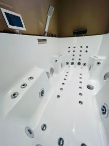een badkuip in een kamer met een computer aan de muur bij Caprice Gruissanais Suite avec Spa privatif in Gruissan