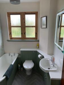 a bathroom with a sink and a toilet and a bath tub at Glenerne 3 bedroom Cottage in Elgin +10 photos