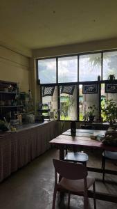 eine Küche mit einem Tisch und einer Theke mit Fenstern in der Unterkunft Yorsong Hostel Pai in Kampong Huaibū