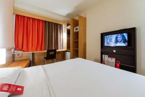 a hotel room with a bed and a flat screen tv at ibis Novo Hamburgo in Novo Hamburgo
