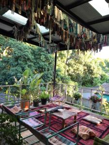 eine Terrasse mit Tisch, Stühlen und Pflanzen in der Unterkunft Yorsong Hostel Pai in Kampong Huaibū