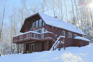 a cabin in the woods with snow on the ground at Spring Hill 70 in Campton