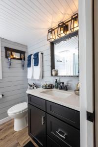a bathroom with a sink and a toilet and a mirror at Hagrid's Hut - Harry Potter Riverfront Experience in New Richmond +97 photos