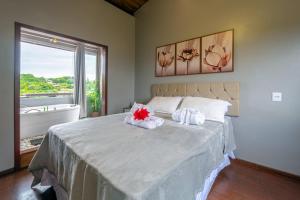 a bedroom with a bed with towels on it at Pousada Natribus Rosa in Praia do Rosa +174 photos