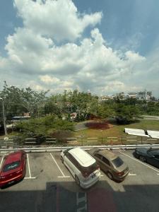 eine Gruppe von Autos auf einem Parkplatz geparkt in der Unterkunft Luna Bliss Taman Koop AST Lobak Budget Hotel Room in Seremban + 2 Fotos