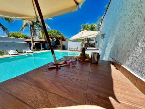 a view of a swimming pool with an umbrella at Pousada Areia in Saquarema