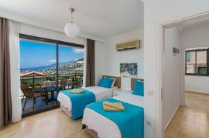 een slaapkamer met twee bedden en een balkon bij Villa Vala in Kalkan