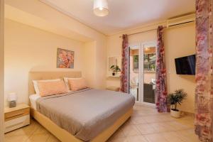 a bedroom with a bed and a tv and a window at Villa Elea Corfu by Villa Plus in Paleokastritsa