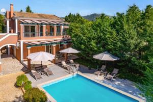 an aerial view of a house with a pool and umbrellas at Villa Elea Corfu by Villa Plus in Paleokastritsa