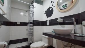 ein Badezimmer mit Toilette, Waschbecken und Spiegel in der Unterkunft Edificio Sir William - Punta hermosa - Lima, Peru in Punta Hermosa + 43 Fotos
