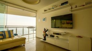 ein Wohnzimmer mit Sofa und Fernseher in der Unterkunft Edificio Sir William - Punta hermosa - Lima, Peru in Punta Hermosa