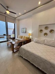 a bedroom with a bed and a couch and a table at Penthouse Studio 2 blocks from Los Muertos beach in Puerto Vallarta