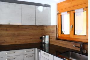 a kitchen with white cabinets and a sink at Ferienwohnung an der Seez in Mels