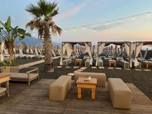 a beach with chairs and tables and a palm tree at Palazzo Maiori in Torre Annunziata