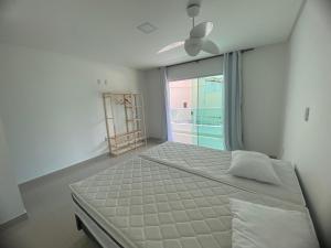 a bedroom with a large bed and a window at Requinte e Conforto em Guarapari in Guarapari