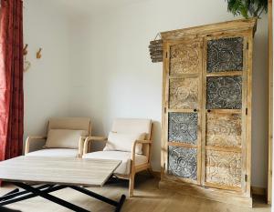een kamer met 2 stoelen en een houten kast bij Caprice Gruissanais Suite avec Spa privatif in Gruissan +15 foto's