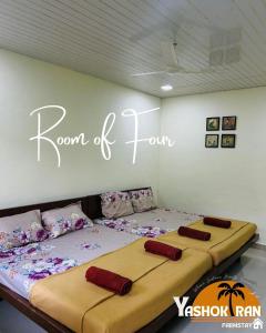 2 camas en una habitación con un cartel en la pared en Yashokiran Farmstay, en Borlai