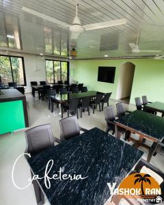 Una sala de conferencias con mesas, sillas y televisión. en Yashokiran Farmstay, en Borlai 1 foto más
