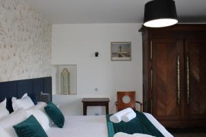 a bedroom with two beds with green and white pillows at Domaine Des Piéris - Chambres d'Hôtes in Grandcamp-Maisy