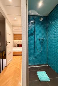 Un baño con ducha con azulejos azules. en Little Escape House with Sauna & perfect Location, en Thun