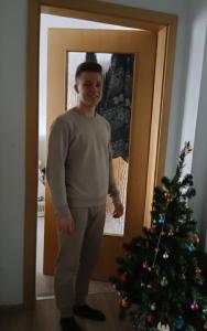 Doppelbett für Zwei في دينسلاكن: رجل يقف أمام شجرة عيد الميلاد