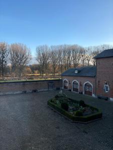 a brick building with a garden in a courtyard at 'T Rood Kasteel in Hasselt