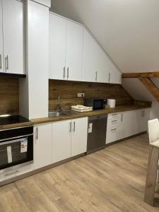 a kitchen with white cabinets and a sink at La Casa 2 in Sombor