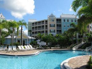 a large swimming pool with chairs and a building at Calypso Cay Vacation Villas in Kissimmee