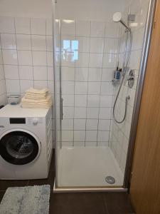 y baño con ducha y lavadora. en Knusperhaus mit Garten, en Salzburgo