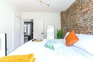 um quarto com uma cama branca e uma parede de tijolos em Jungle House Luxury Homes - Columbus Downtown Short North - Walk to Convention Center & Nationwide Arena - Sleeps up to 8 - Free Parking - Over 5,800 Five Stars em Columbus mais 60 fotografias