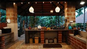 une cuisine avec un comptoir dans une pièce avec des arbres dans l'établissement Happy Haven Farmstay, à Mangalore 36 autres photos