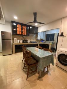 Una cocina con una mesa con sillas y un refrigerador. en The Majestic Home Ampang, en Kuala Lumpur