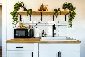 um balcão de cozinha com pia e micro-ondas em Jungle House Columbus - Luxury Downtown Homes Free Parking em Columbus