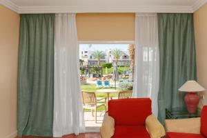 a living room with a red chair and a large window at Jaz Sharm Dream Vacation Club Time Share - Reservation only on Saturdays - Min stay 7 Days in Sharm El Sheikh