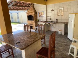 een keuken met een tafel en een bakstenen oven bij Casa no cumbuco in Caucaia