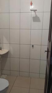 een badkamer met een douche, toilet en wastafel bij Casa dunas in Guajiru