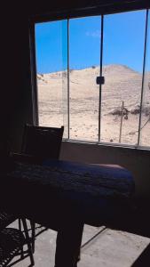 een piano in een kamer met uitzicht op de woestijn bij Casa dunas in Guajiru