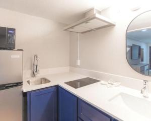 a kitchen with blue cabinets and a sink and a mirror at Economy Suites Extended Stay in Tulsa