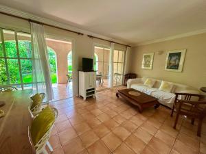a living room with a couch and a table at Les Restanques Maison 12 Lac in Grimaud