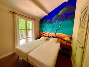 a bedroom with a bed with a painting on the wall at Les Restanques Maison 12 Lac in Grimaud +45 photos
