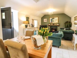 a living room with a table with flowers on it at The Talkhouse Cottage in Caersws