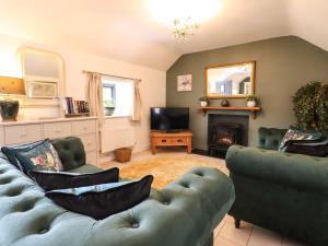 a living room with a couch and a fireplace at The Talkhouse Cottage in Caersws